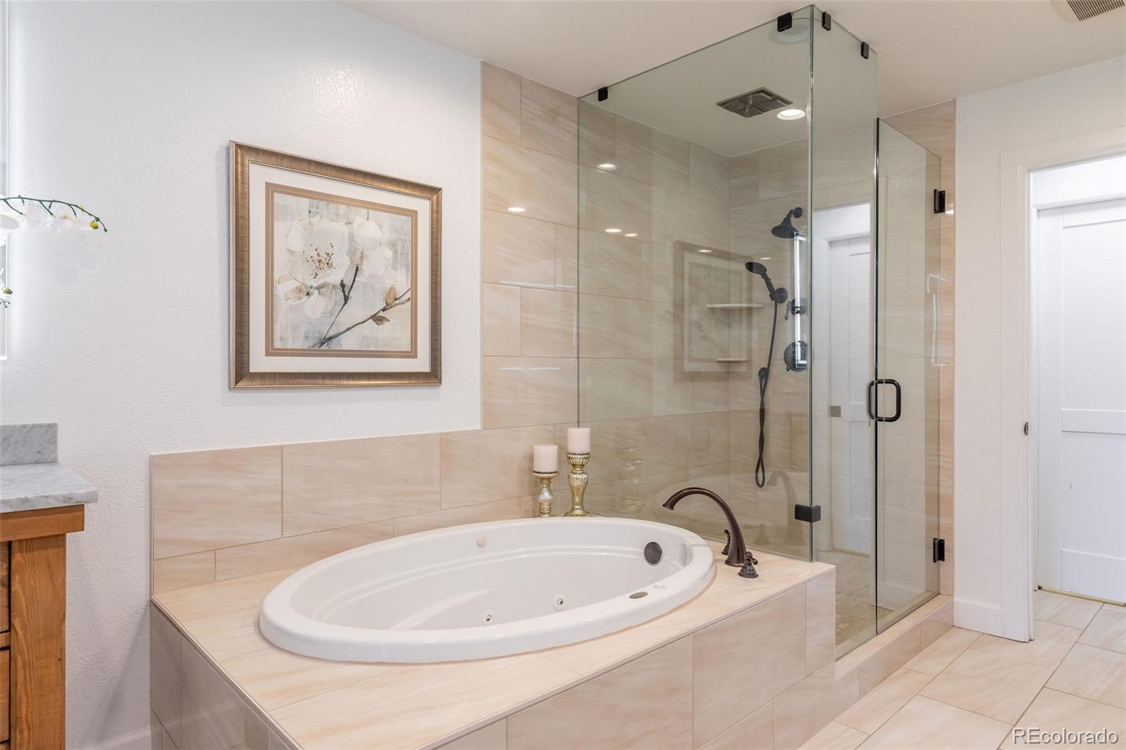968 Summer Spring View Colorado Springs, CO 80906 - Photo 23 of 40 a bathroom with a tub a sink and glass door