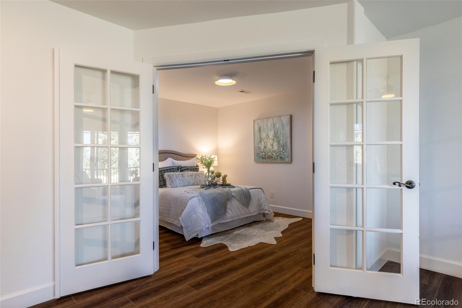 968 Summer Spring View Colorado Springs, CO 80906 - Photo 26 of 40 a bedroom with a bed and wooden floor