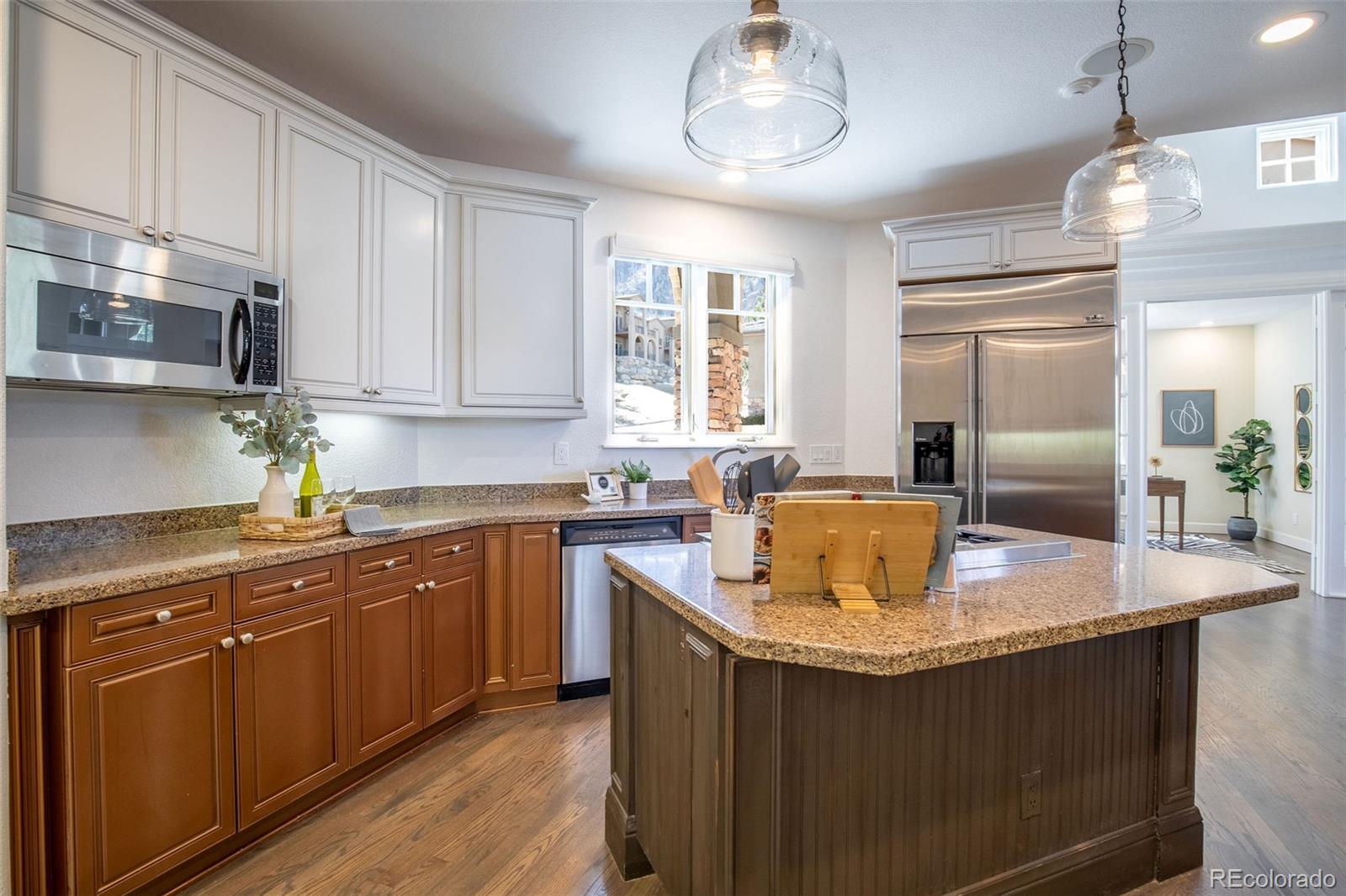 968 Summer Spring View Colorado Springs, CO 80906 - Photo 6 of 40 a kitchen with stainless steel appliances granite countertop a sink dishwasher and a refrigerator with wooden cabinets