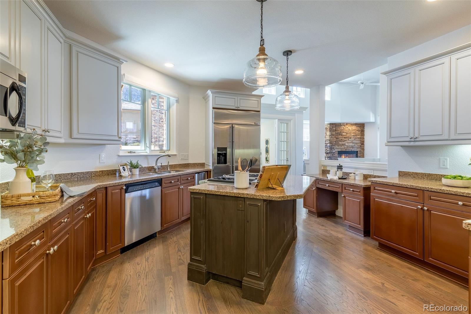 968 Summer Spring View Colorado Springs, CO 80906 - Photo 9 of 40 a kitchen with granite countertop a sink stove and wooden floor