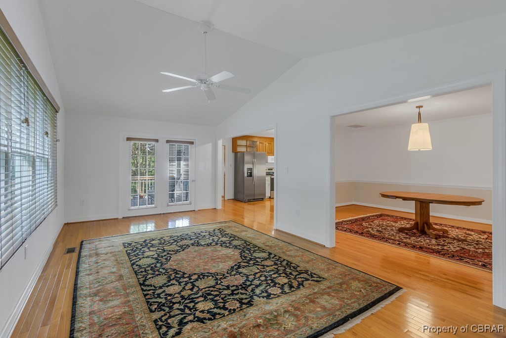 35 Powhatan Road Kilmarnock, VA 22482 - Photo 22 of 42 Living area featuring lofted ceiling, baseboards, light wood finished floors, visible vents, and ceiling fan