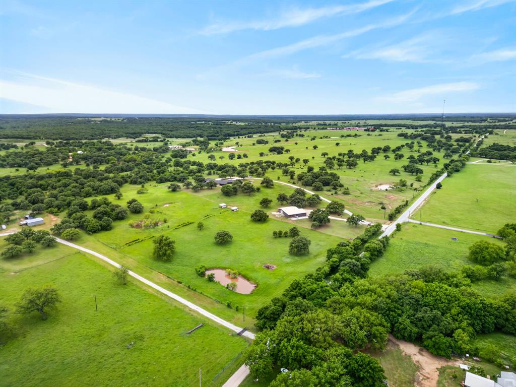 1080 North Greenbrier Road Nocona, TX 76255 - Photo 35 of 40 Expansive property featuring verdant pastures, scattered mature trees, and a visible pond