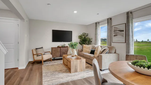 a living room with furniture a flat screen tv and a floor to ceiling window