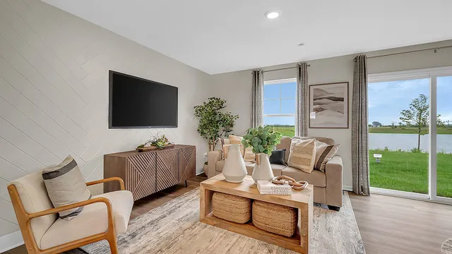 a living room with furniture a flat screen tv and a floor to ceiling window
