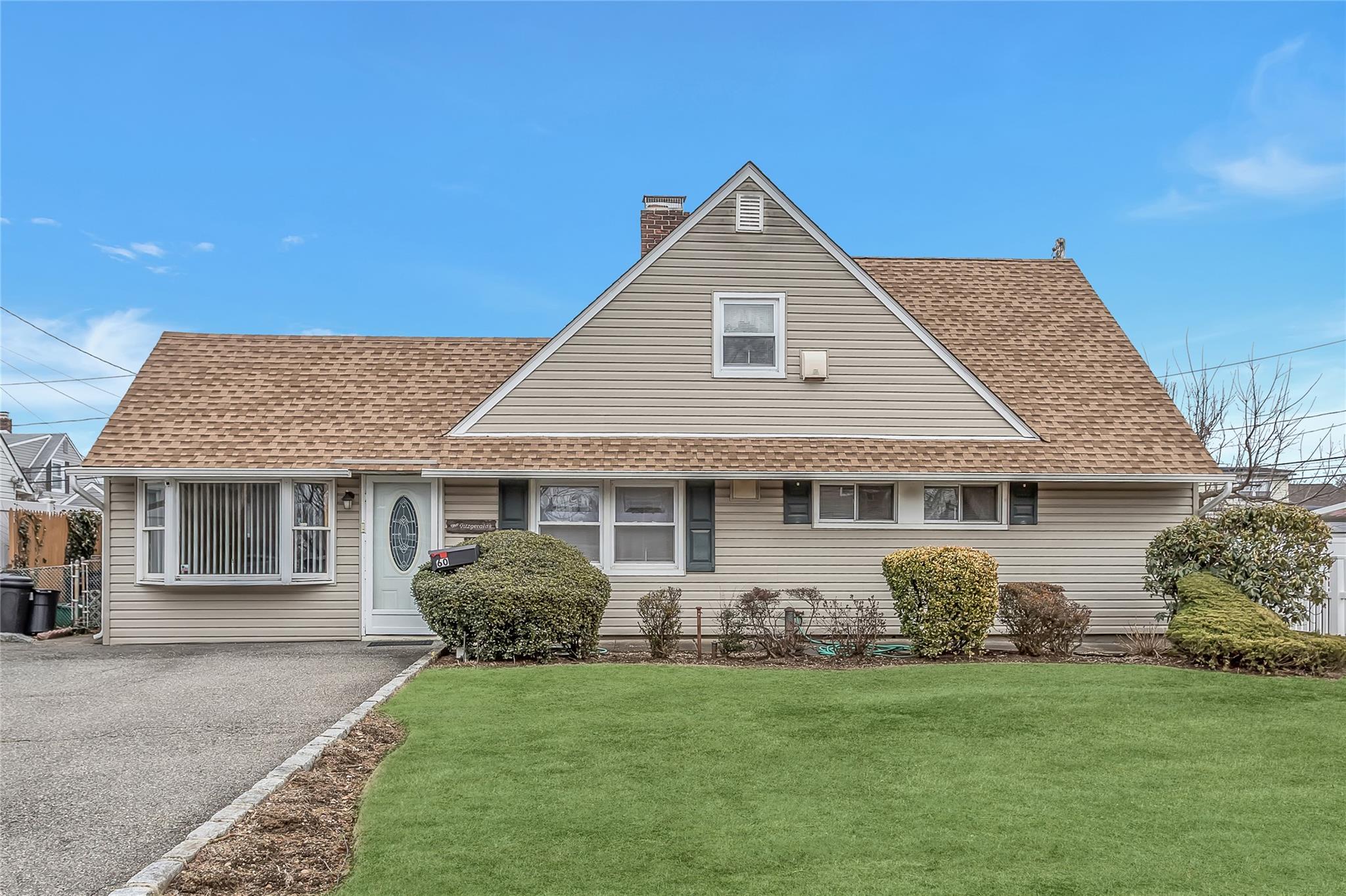 60 Barrister Road Levittown, NY 11756 - Photo 1 of 1 View of front of home with a shingled roof, a chimney, a front yard, and aphalt driveway