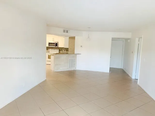 a view of a kitchen with a sink and a refrigerator