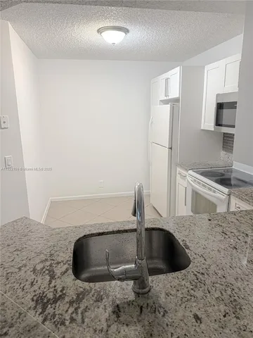 a kitchen with a sink and a refrigerator