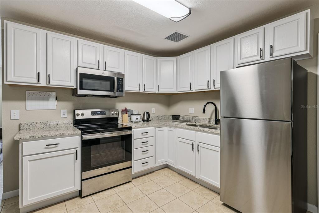 725 3rd Street Orange City, FL 32763 - Photo 5 of 15 a kitchen with cabinets stainless steel appliances and a sink