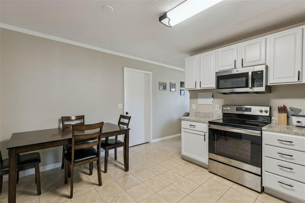 725 3rd Street Orange City, FL 32763 - Photo 7 of 15 a kitchen with stainless steel appliances a stove a sink island and a refrigerator