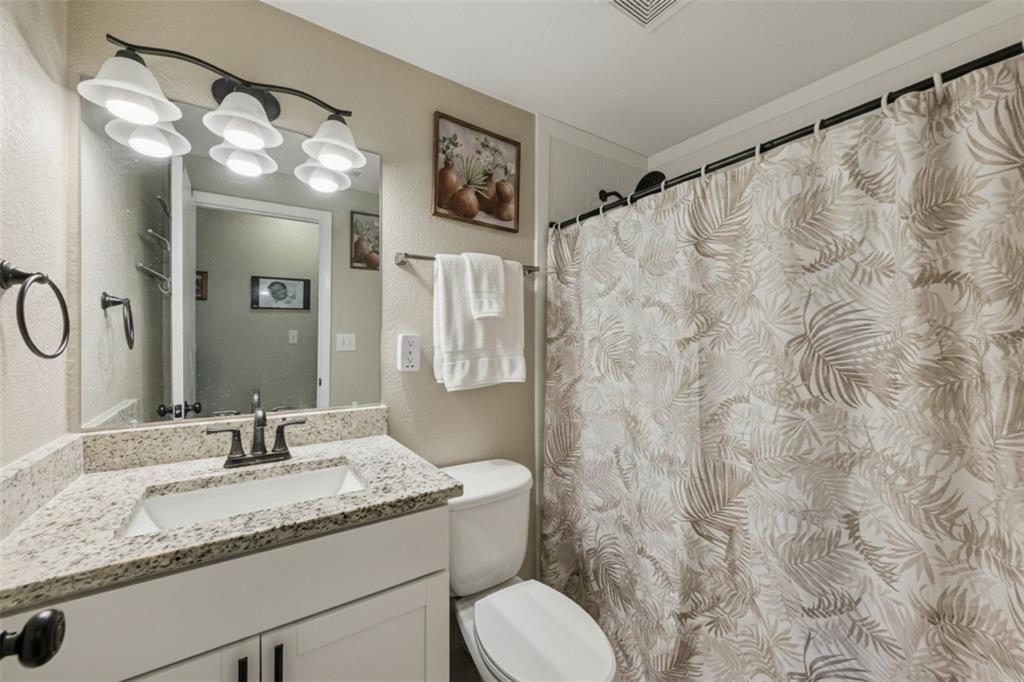 725 3rd Street Orange City, FL 32763 - Photo 10 of 15 a bathroom with a granite countertop sink a toilet and a mirror