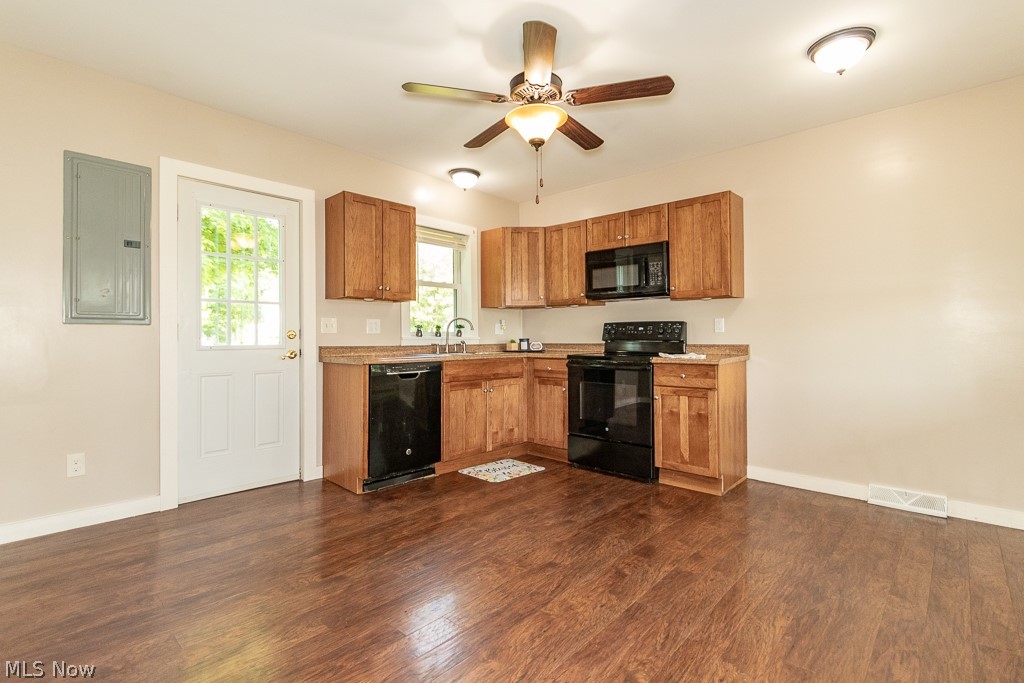 16506 Leroy Thompson Road Thompson, OH 44086 - Photo 34 of 41 Kitchen with electric panel, dark wood-type flooring, black appliances, and ceiling fan