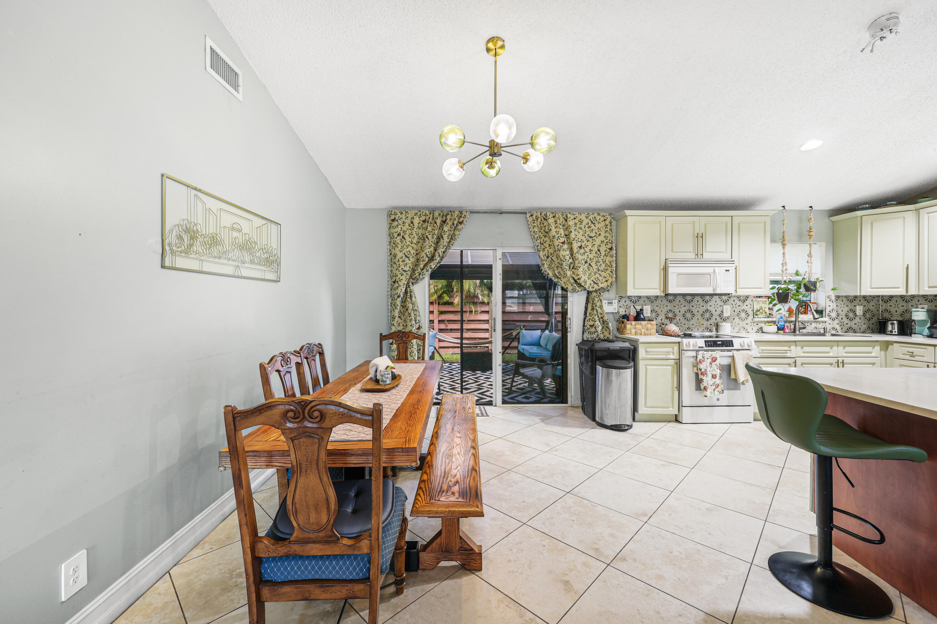 7527 Southwest 7th Street North Lauderdale, FL 33068 - Photo 26 of 34 a dining room filled chandelier and kitchen view