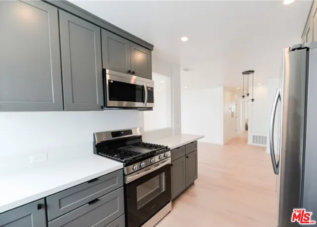 a kitchen with stainless steel appliances a refrigerator a stove and a microwave