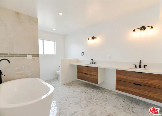 a bathroom with a tub sink and mirror
