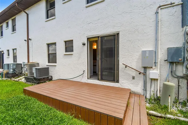 a view of a yard with plants and large trees