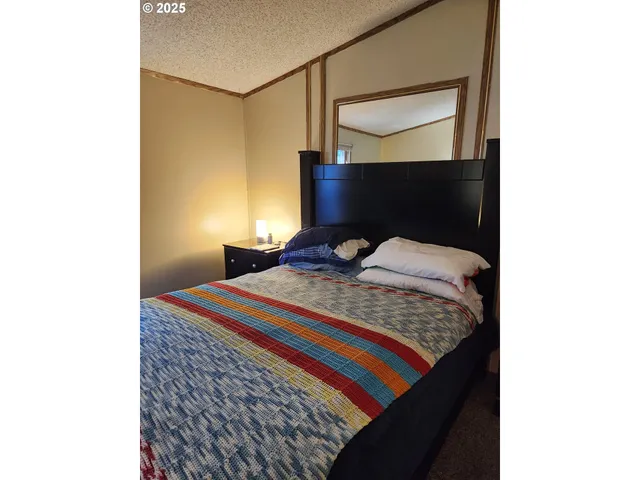 a bedroom with a bed and a painting on the wall