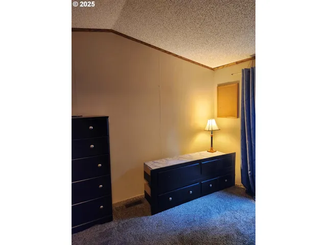 a room with a lamp and a dresser