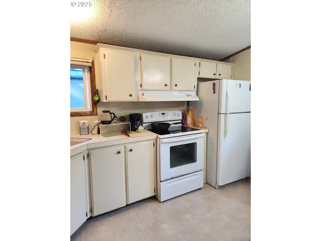 a view of kitchen with stainless steel appliances white cabinets and a refrigerator