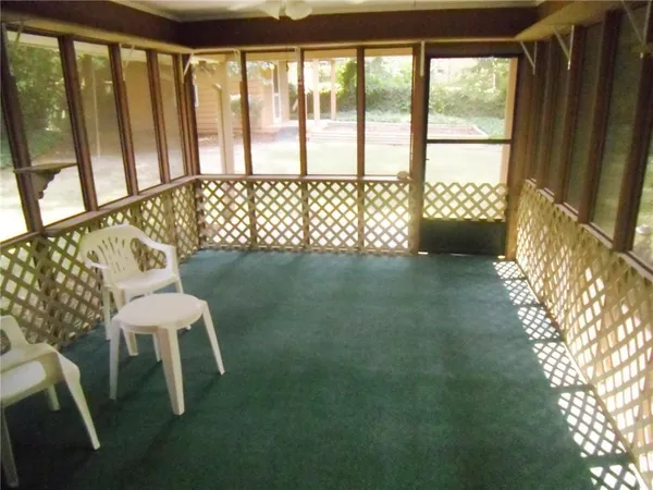 a view of a porch with furniture and a yard
