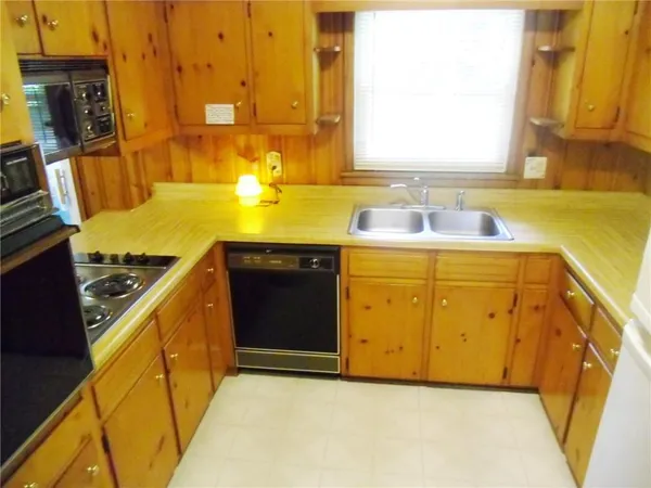 a view of a kitchen with a sink and wooden cabinets
