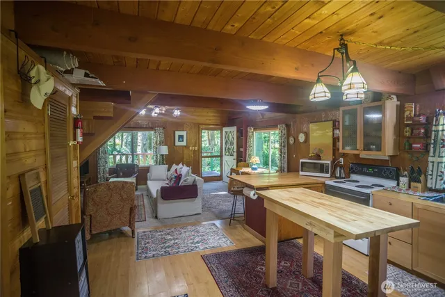 a room with kitchen island a stove and a chandelier