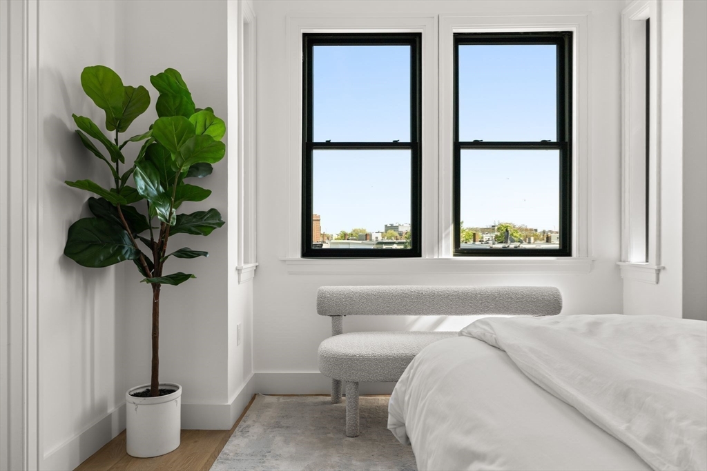 100 Bennington Street, Unit PH4A Boston, MA 02128 - Photo 28 of 41 a bedroom with a bed potted plant and a window