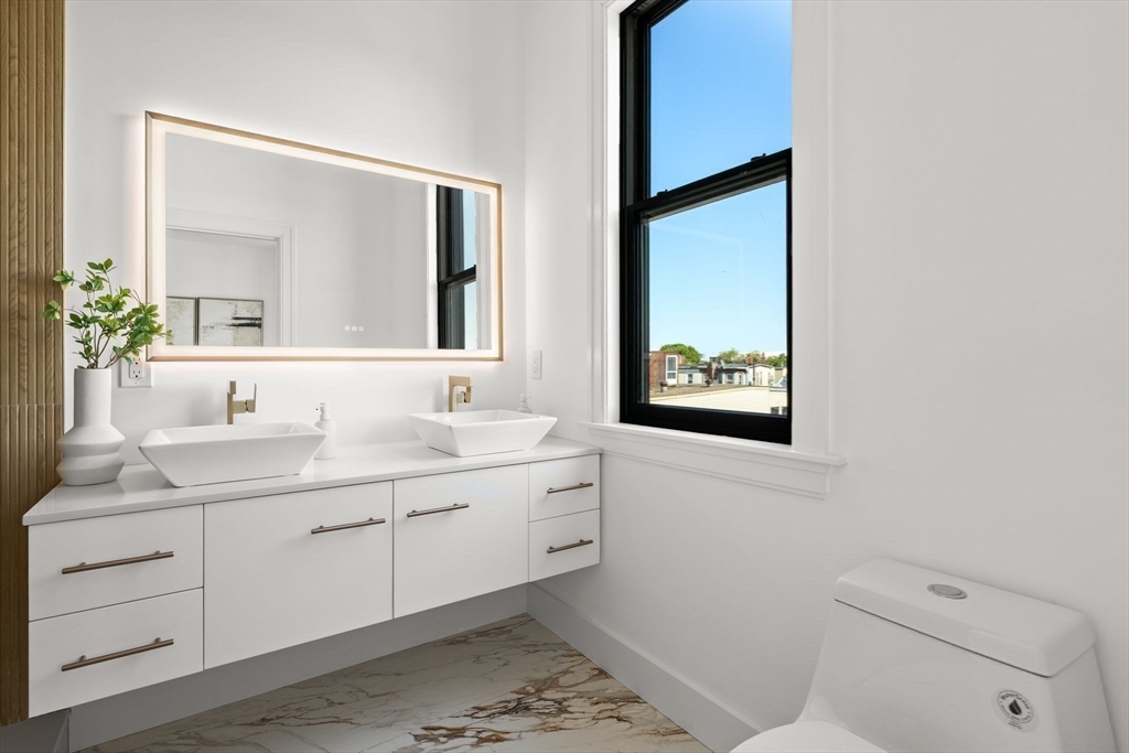 100 Bennington Street, Unit PH4A Boston, MA 02128 - Photo 30 of 41 a bathroom with a toilet sink and mirror