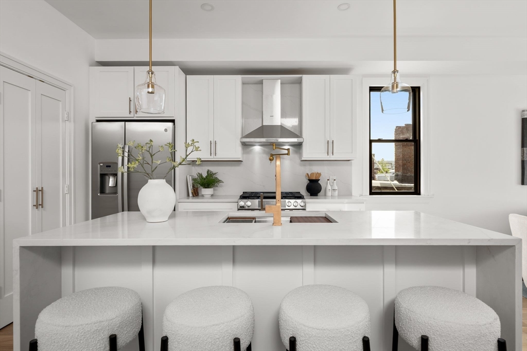 100 Bennington Street, Unit PH4A Boston, MA 02128 - Photo 3 of 41 a kitchen with stainless steel appliances a table chairs and cabinets