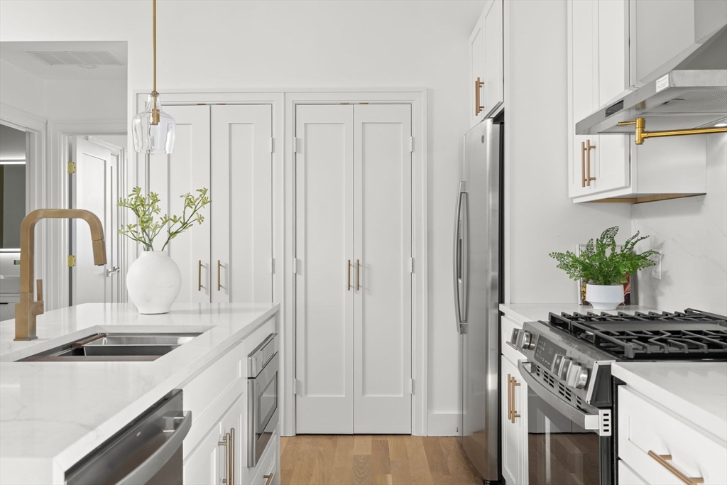 100 Bennington Street, Unit PH4A Boston, MA 02128 - Photo 7 of 41 a kitchen with stainless steel appliances a sink a stove and a refrigerator