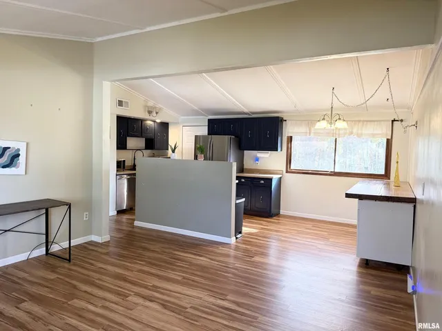 a view of kitchen with microwave and refrigerator
