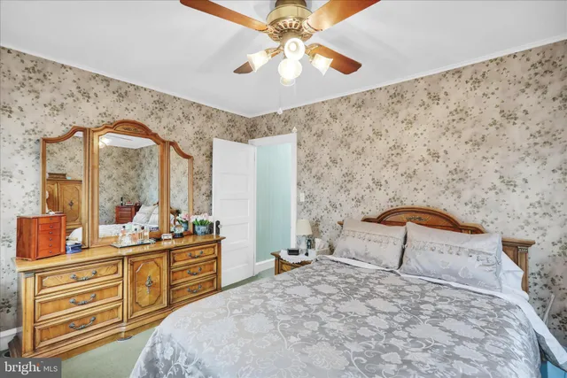 a bedroom with a bed dresser and a large window