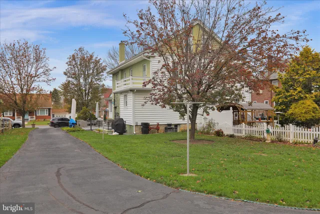 a view of a house with a big yard and large trees