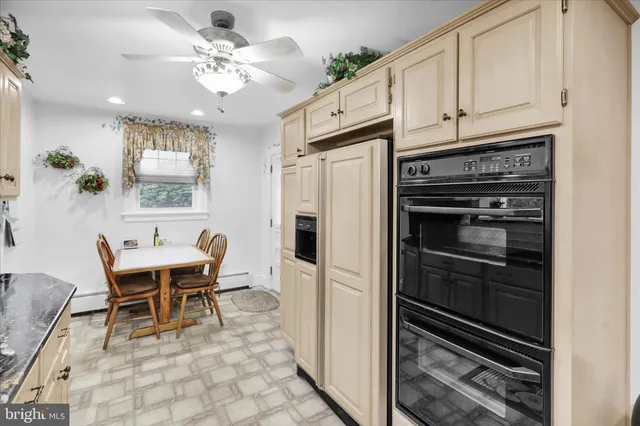 a kitchen with stainless steel appliances a stove a refrigerator and white cabinets