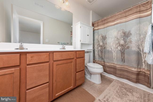 2082 Mallard Lane Locust Grove, VA 22508 - Photo 21 of 32 a bathroom with a granite countertop sink toilet a mirror and shower