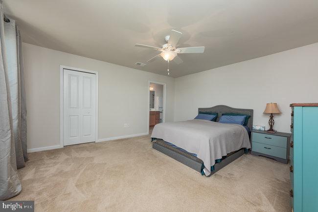 2082 Mallard Lane Locust Grove, VA 22508 - Photo 23 of 32 a spacious bedroom with a bed and a ceiling fan