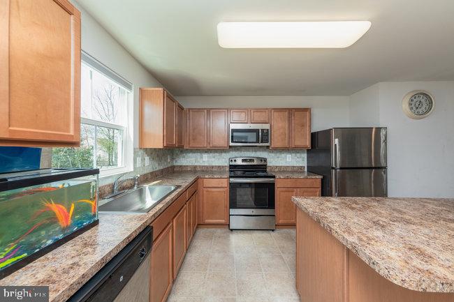 2082 Mallard Lane Locust Grove, VA 22508 - Photo 8 of 32 a kitchen with stainless steel appliances granite countertop a sink stove microwave and refrigerator