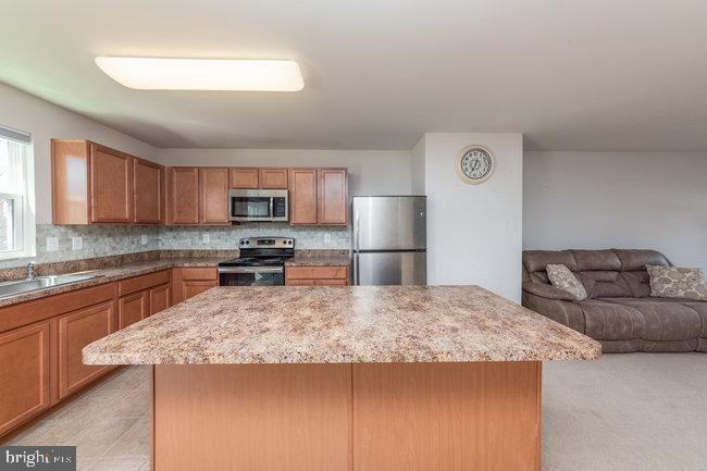 2082 Mallard Lane Locust Grove, VA 22508 - Photo 9 of 32 a kitchen with granite countertop a refrigerator and a stove top oven