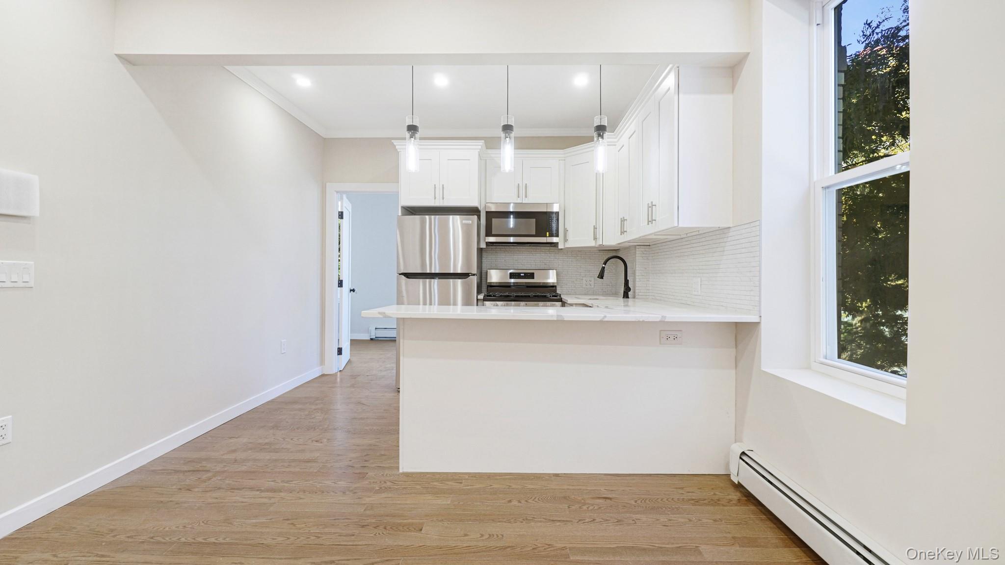 386 Chauncey Street, Unit 1 Brooklyn, NY 11233 - Photo 1 of 11 a kitchen with kitchen island a sink appliances and cabinets
