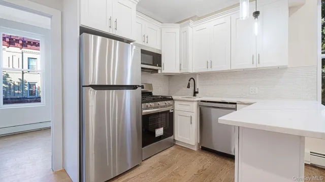 a kitchen with white cabinets and white appliances