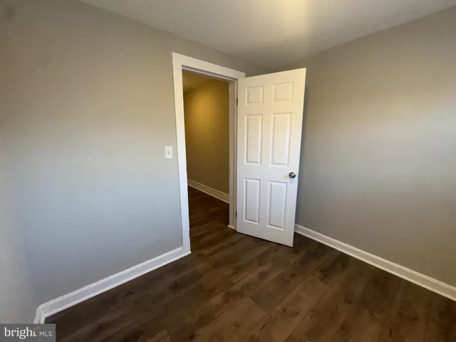 an empty room with wooden floor and closet