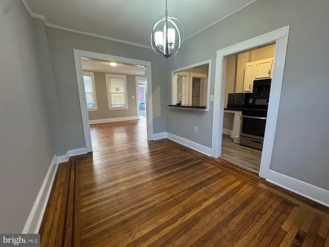 a view of a room with wooden floor staircase and a kitchen space