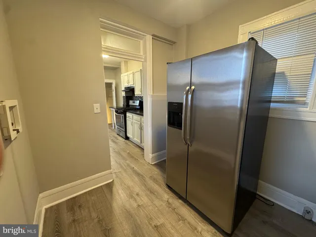 a view of a refrigerator in kitchen and a glass window