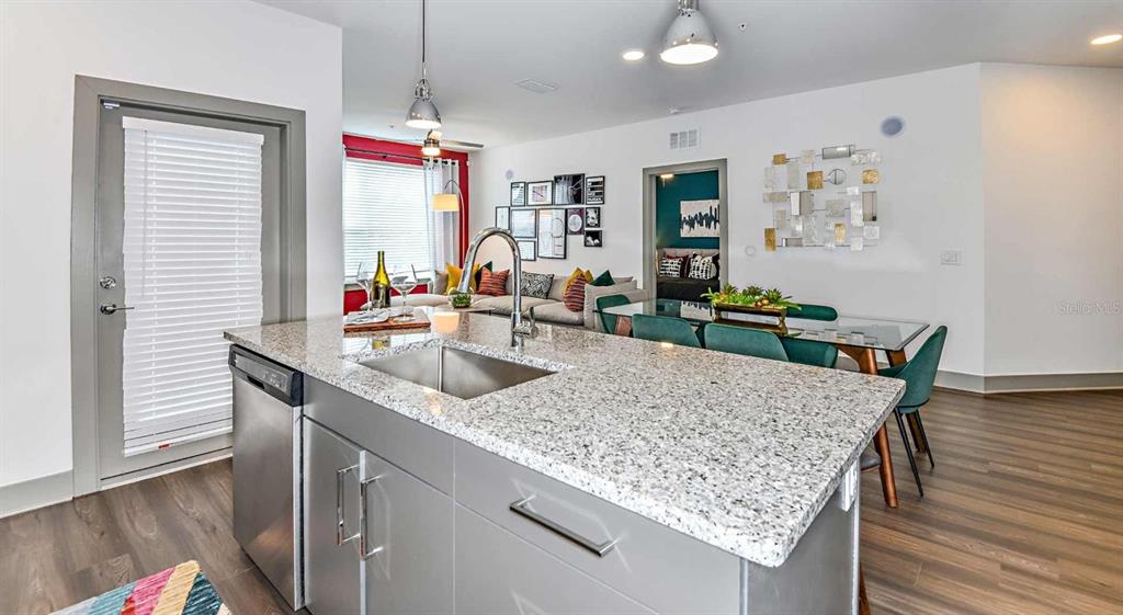 1040 Jamison Loop, Unit ELEMENT Kissimmee, FL 34744 - Photo 5 of 18 a kitchen with granite countertop sink and wooden floor