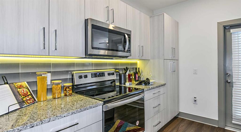 1040 Jamison Loop, Unit ELEMENT Kissimmee, FL 34744 - Photo 7 of 18 a kitchen with a stove and a microwave