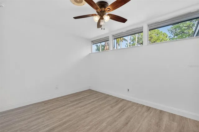 an empty room with wooden floor & closet area