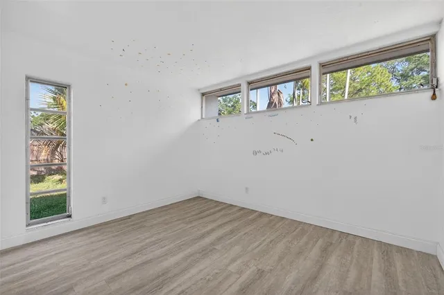a view of a room with wooden floor and a window
