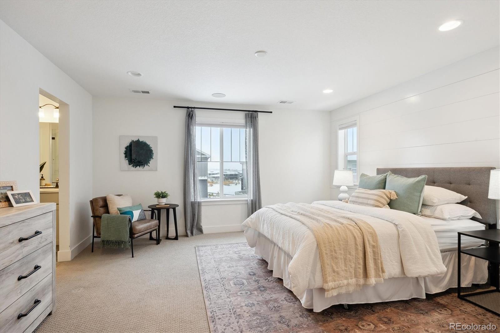 12841 Red Rosa Circle Parker, CO 80134 - Photo 15 of 29 a spacious bedroom with a bed a table and large windows