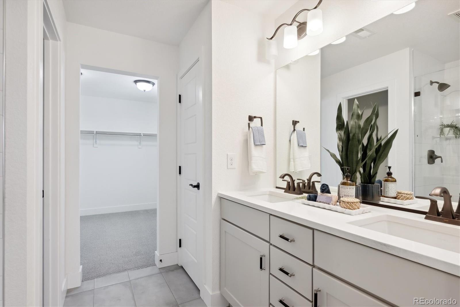 12841 Red Rosa Circle Parker, CO 80134 - Photo 16 of 29 a bathroom with double vanity sink a mirror and a shower