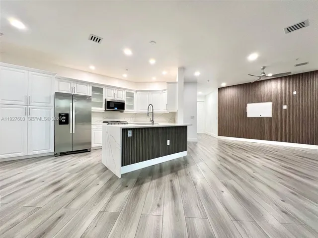 a large kitchen with stainless steel appliances granite countertop a large counter top and a stove