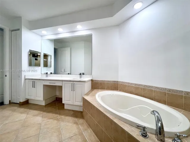 a bathroom with a tub sink and mirror